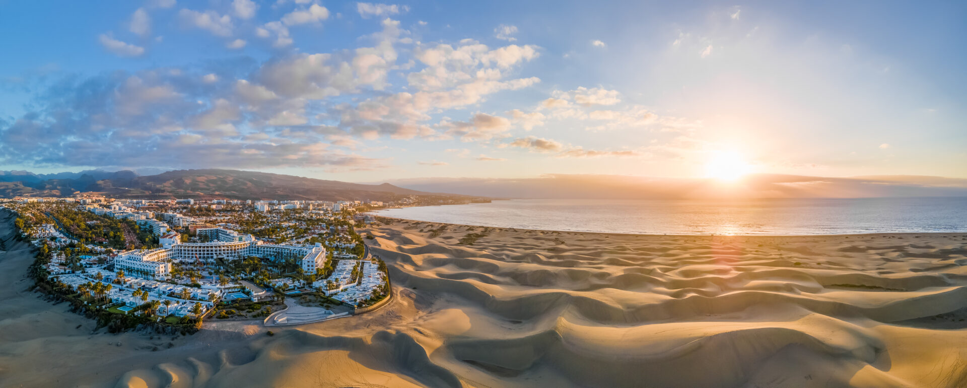 Landscape with Maspalomas town and golden sand dunes at sunrise,