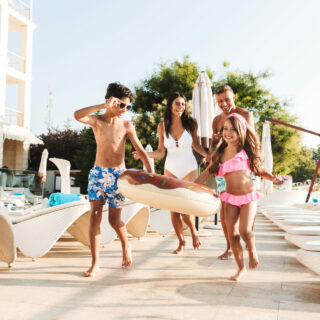 Familie im Urlaub am Pool