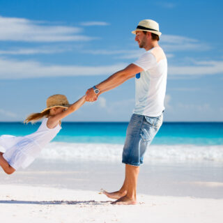 Mann mit Kind am Strand