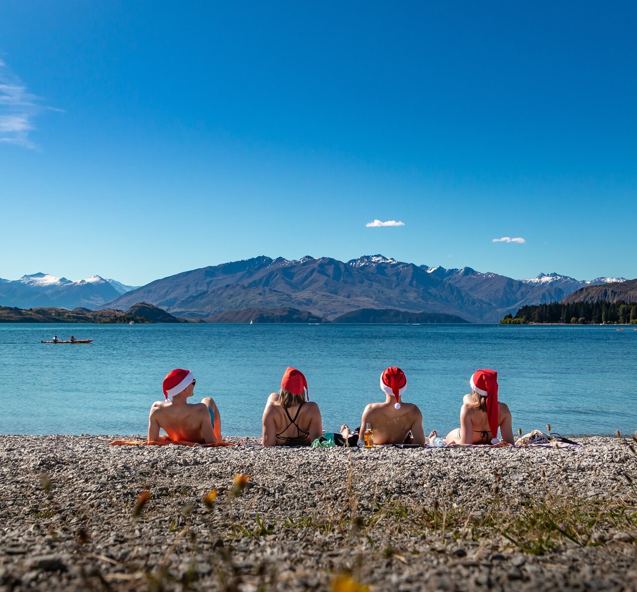 Neuseeland Strand von Wanaka, Leute mit Weihnachtsmützen sonnen sich