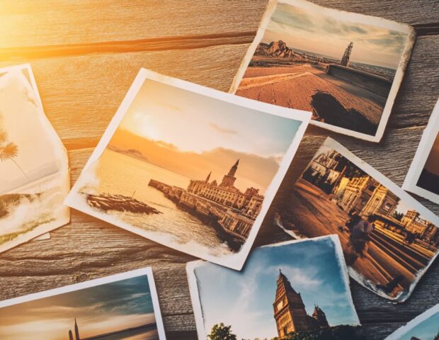 Fotoreise Header, verschiedene Urlaubsfotos auf einem Tisch ausgebreitet
