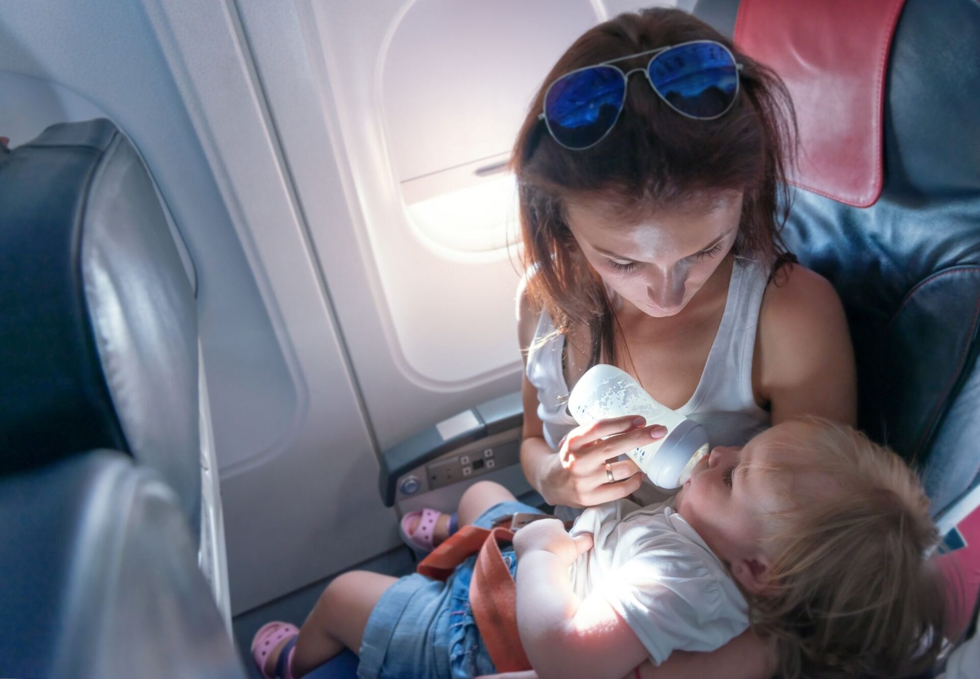 Mutter gibt Baby im Flugzeug die Flasche