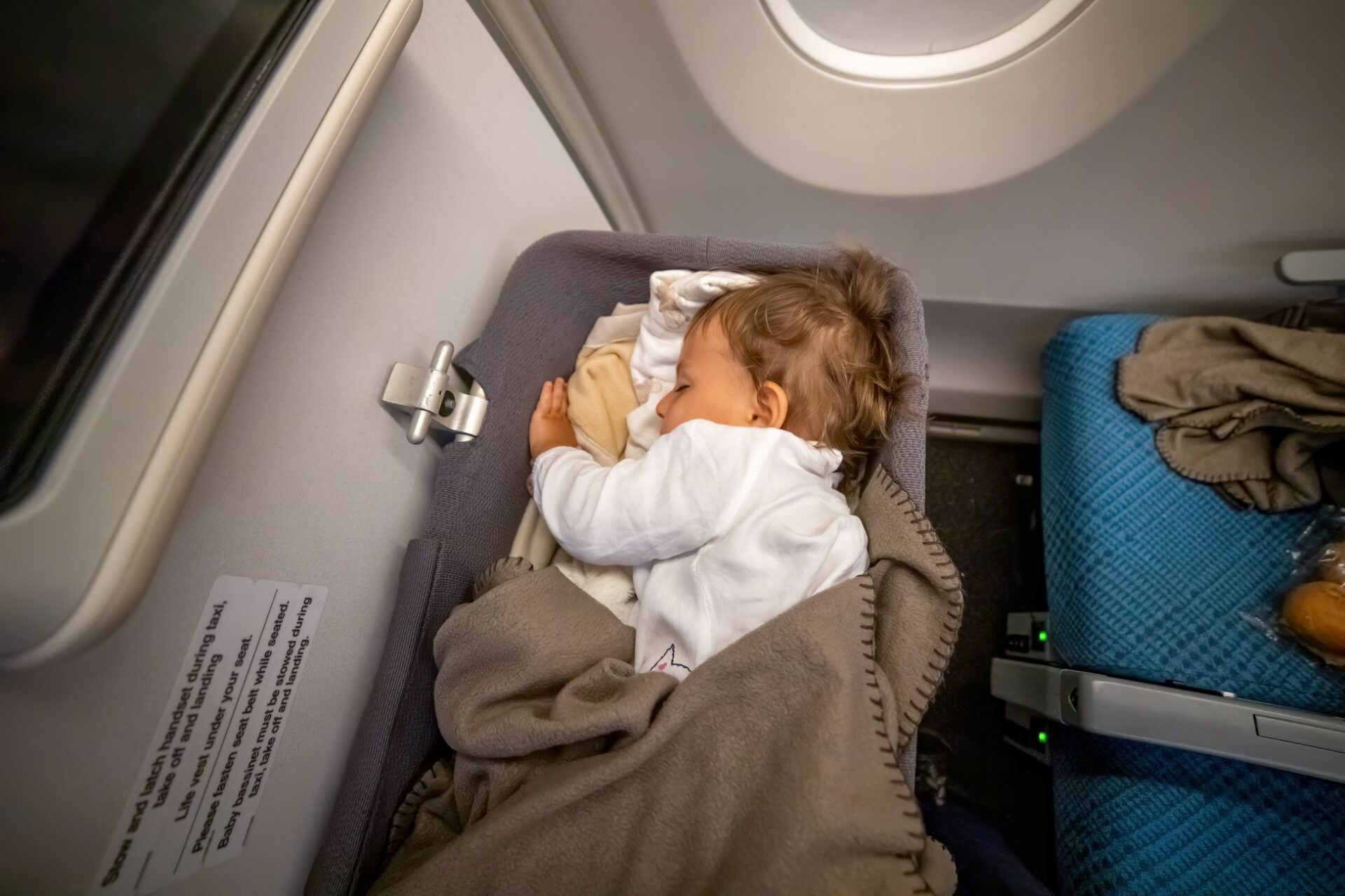 Schlafendes Kleinkind im Flugzeugbettchen