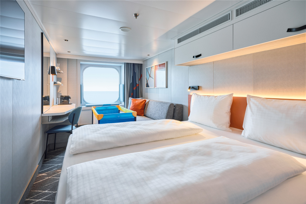 Außenkabine mit Bett vorne und Babybett auf der Mein Schiff Relax